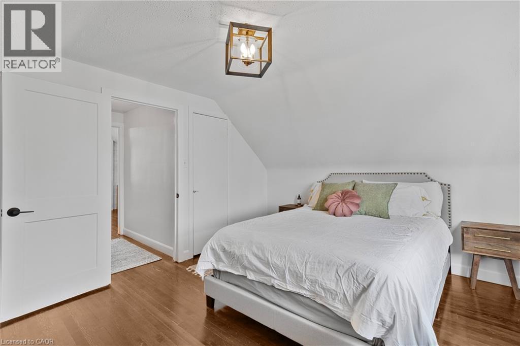 Bedroom with vaulted ceiling, wood finished floors, and a textured ceiling - 191 East 11Th Street, Hamilton, ON - Indoor Photo Showing Bedroom