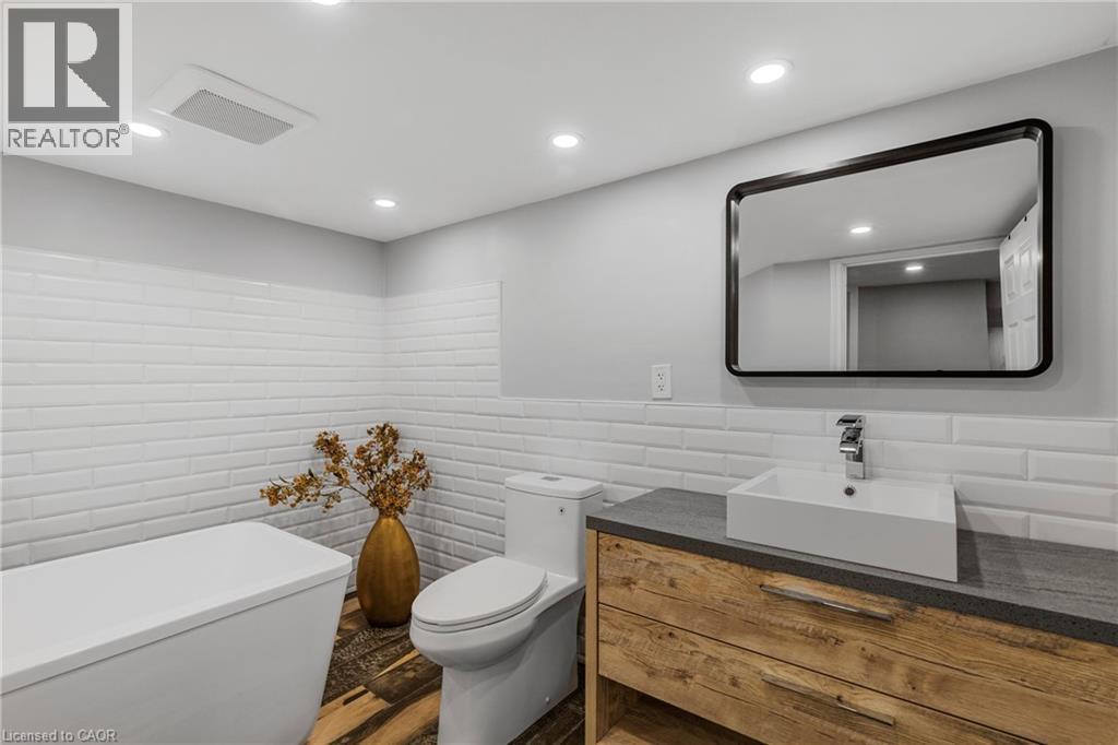 Bathroom featuring vanity, tile walls, recessed lighting, and dark wood-style floors - 191 East 11Th Street, Hamilton, ON - Indoor Photo Showing Bathroom