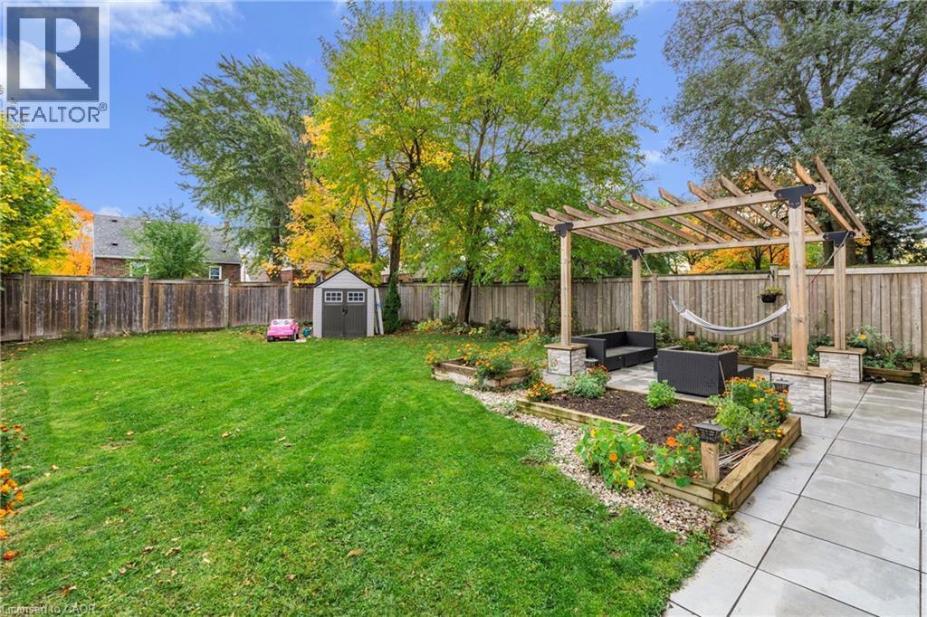 Fenced backyard with a patio, a pergola, a shed, a garden, and an outdoor hangout area - 191 East 11Th Street, Hamilton, ON - Outdoor With Backyard
