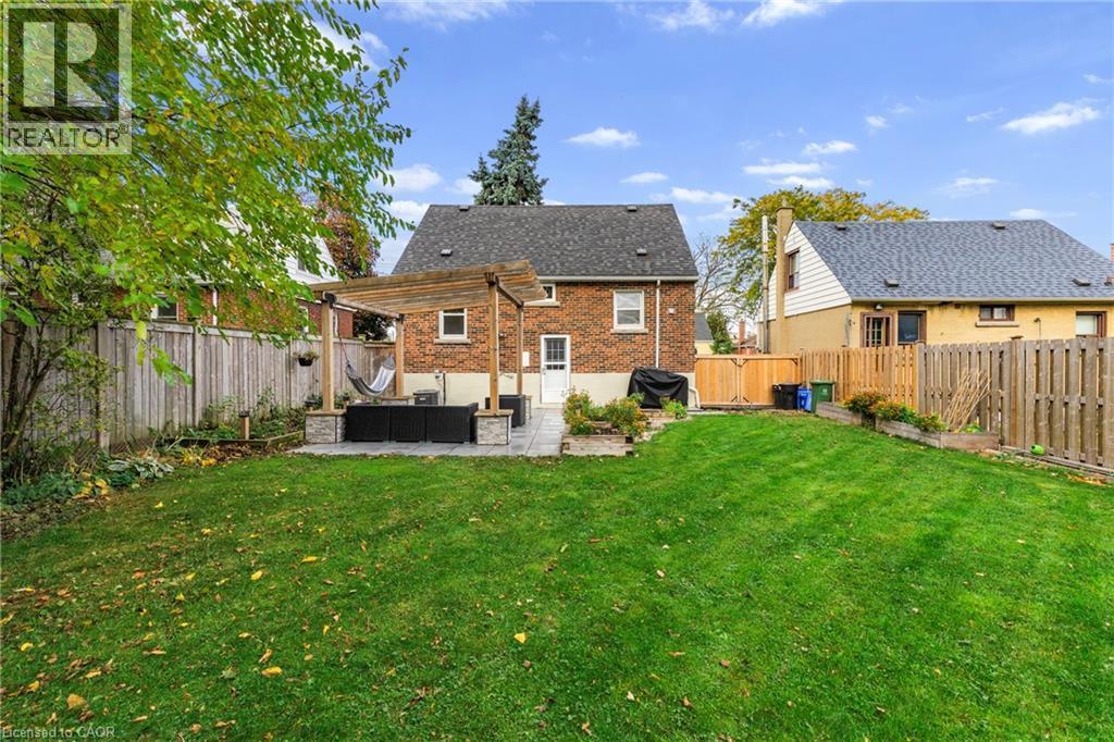 Back of house with a patio area, a fenced backyard, brick siding, and a pergola - 191 East 11Th Street, Hamilton, ON - Outdoor