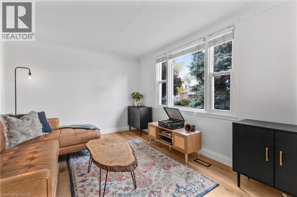 Living room with light wood-style flooring and baseboards - 191 East 11Th Street, Hamilton, ON - Indoor Photo Showing Living Room