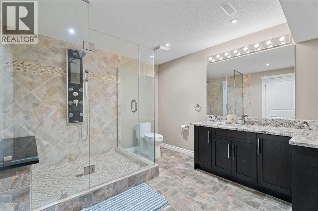 The bathroom has a luxury shower system with numerous jets and a big bench to relax on - 113 Aspen Stone Place Sw, Calgary, AB - Indoor Photo Showing Bathroom