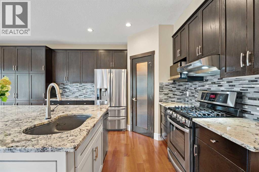 Gas range, corner pantry, kidney shaped undermount sink - 113 Aspen Stone Place Sw, Calgary, AB - Indoor Photo Showing Kitchen With Upgraded Kitchen
