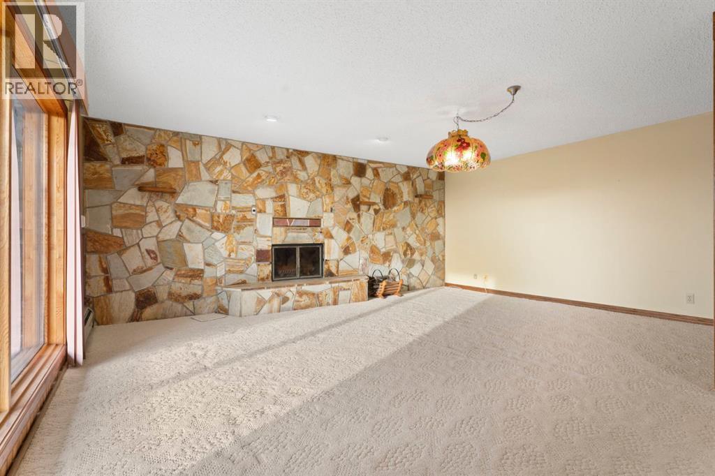 39 Coach Gate Way Sw, Calgary, AB - Indoor Photo Showing Other Room With Fireplace