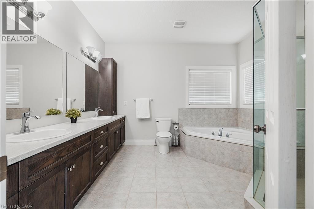 Bathroom featuring a bath, double vanity, light tile patterned flooring, and a stall shower - 346 Moorlands Crescent, Kitchener, ON - Indoor Photo Showing Bathroom