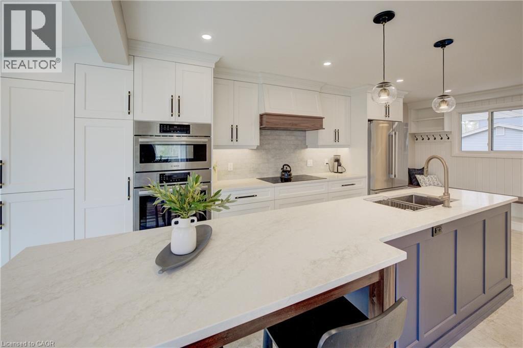 Kitchen featuring appliances with stainless steel finishes, decorative light fixtures, light stone countertops, white cabinetry, and recessed lighting - 279 Ferndale Place, Waterloo, ON - Indoor Photo Showing Kitchen With Double Sink With Upgraded Kitchen