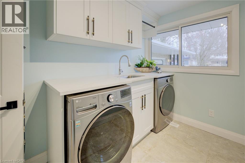 Laundry room featuring washing machine and dryer and cabinet space - 279 Ferndale Place, Waterloo, ON - Indoor Photo Showing Laundry Room