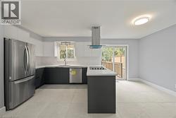 Kitchen featuring stainless steel appliances, a peninsula, modern cabinets, white cabinets, and tasteful backsplash -