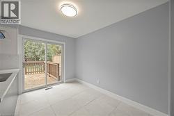 Empty room featuring light tile patterned floors and baseboards -