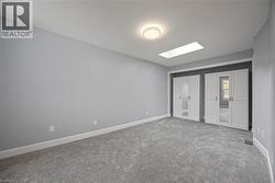 Unfurnished bedroom featuring a skylight, carpet floors, and two closets -
