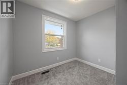 Carpeted spare room featuring baseboards -