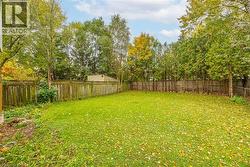 Fenced backyard featuring view of wooded area -