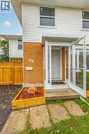 Doorway to property featuring brick siding and a gate -