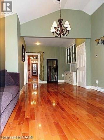 Unfurnished living room with wood-type flooring, a chandelier, and high vaulted ceiling - 134 Courtland Avenue E, Kitchener, ON