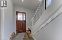Entryway with wood finished floors, stairway, and recessed lighting -