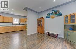 Kitchen with glass insert cabinets, recessed lighting, light countertops, dark wood-style flooring, and white range with electric stovetop -