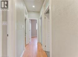Hallway with light wood-style flooring and baseboards -