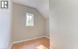 Bonus room with vaulted ceiling and light wood-style flooring -