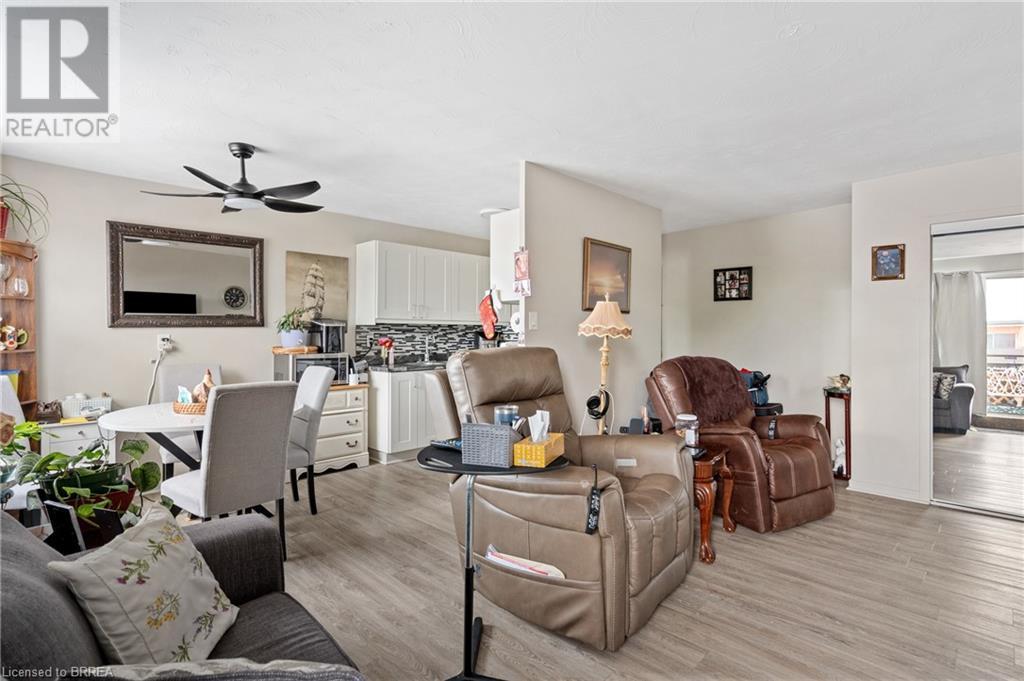 Living room with a ceiling fan, light wood-style flooring, and baseboards - 485 Thorold Road Unit# 323, Welland, ON - Indoor Photo Showing Living Room