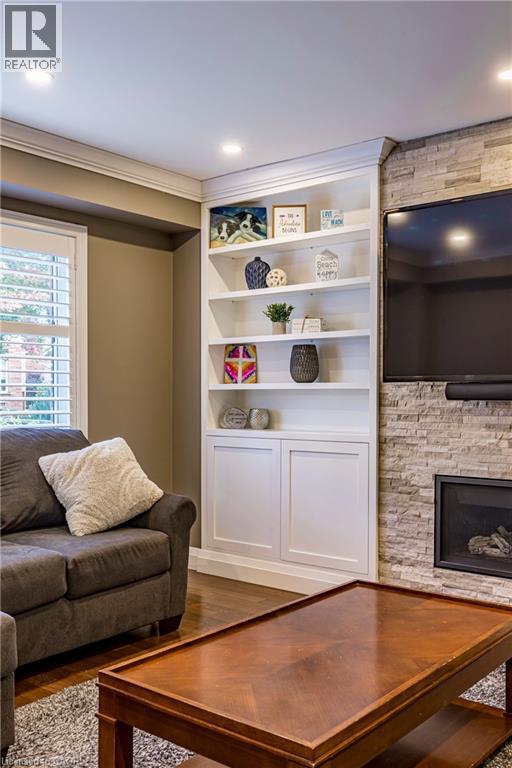 Living room with a fireplace and wood finished floors - 28 Springbreeze Heights, Hamilton, ON - Indoor Photo Showing Living Room With Fireplace