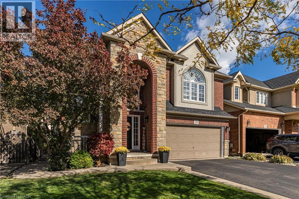Traditional-style house with a garage, asphalt driveway, brick siding, a front lawn, and stone siding - 28 Springbreeze Heights, Hamilton, ON - Outdoor With Facade