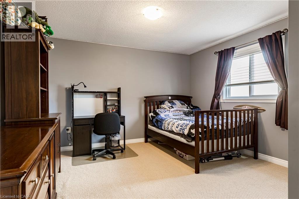 Bedroom featuring light colored carpet, a textured ceiling, and an office area - 28 Springbreeze Heights, Hamilton, ON - Indoor Photo Showing Bedroom