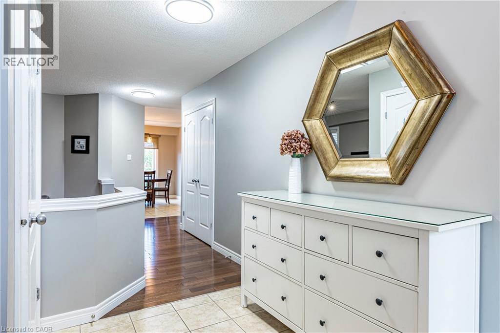Hallway with light tile patterned floors and a textured ceiling - 28 Springbreeze Heights, Hamilton, ON - Indoor Photo Showing Other Room