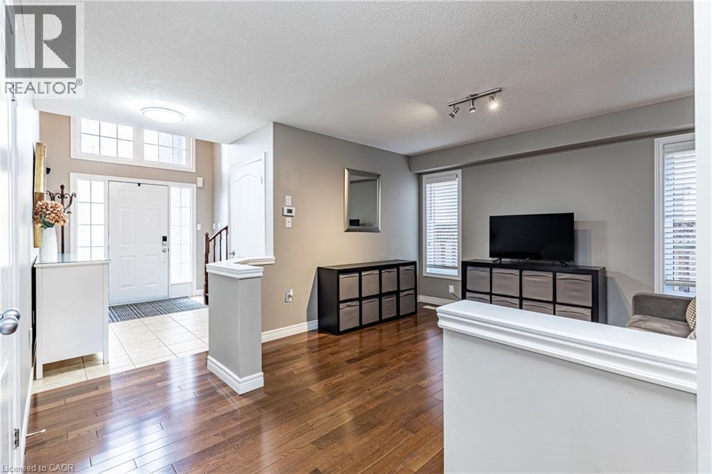 Living room featuring a textured ceiling, plenty of natural light, dark wood finished floors, and rail lighting - 28 Springbreeze Heights, Hamilton, ON - Indoor Photo Showing Living Room