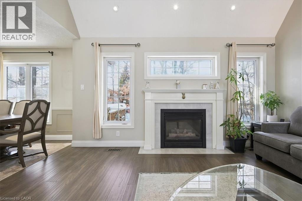 Living room with lofted ceiling, plenty of natural light, hardwood / wood-style flooring, and recessed lighting - 629 Burning Bush Road, Waterloo, ON - Indoor Photo Showing Living Room With Fireplace