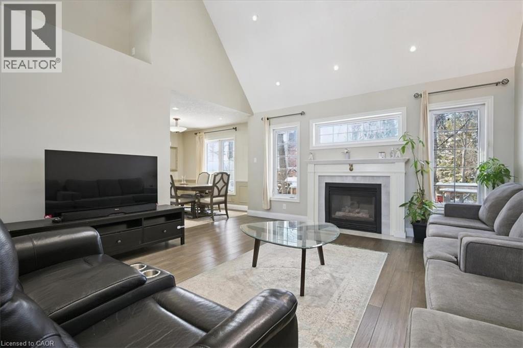 Living room with high vaulted ceiling, dark wood-style floors, a premium fireplace, and recessed lighting - 629 Burning Bush Road, Waterloo, ON - Indoor Photo Showing Living Room With Fireplace