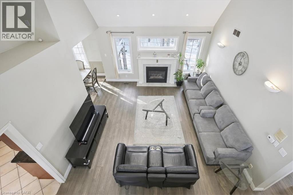 Living room featuring light wood finished floors, a fireplace with flush hearth, lofted ceiling, and recessed lighting - 629 Burning Bush Road, Waterloo, ON - Indoor Photo Showing Living Room With Fireplace