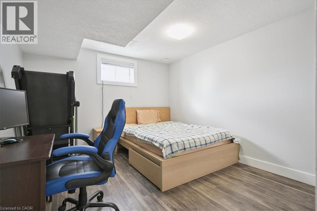 Bedroom featuring a textured ceiling, wood finished floors, and a desk - 629 Burning Bush Road, Waterloo, ON - Indoor