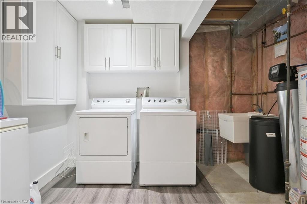 Washroom with separate washer and dryer, cabinet space, and light wood-type flooring - 629 Burning Bush Road, Waterloo, ON - Indoor Photo Showing Laundry Room