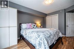 Bedroom with a closet, light wood-style floors, and a textured ceiling -