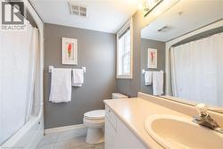 Bathroom featuring vanity, light tile patterned floors, and shower / tub combo with curtain -