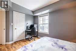 Bedroom featuring light wood-style flooring, a desk, and a textured ceiling -
