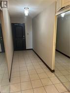 Hall with a chandelier, light tile patterned floors, and a textured ceiling -