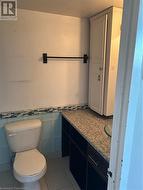 Bathroom with tile patterned floors, vanity, tile walls, and toilet -