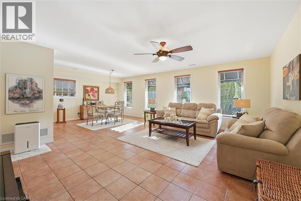 Living room featuring light tile patterned floors and ceiling fan - 21 Arden Avenue, Hamilton, ON - Indoor Photo Showing Living Room