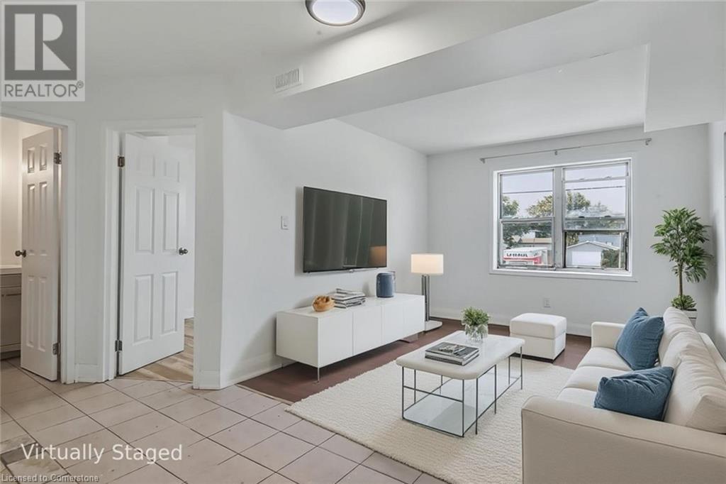 Living area featuring light tile patterned flooring and baseboards - 897 Barton Street E, Hamilton, ON - Indoor