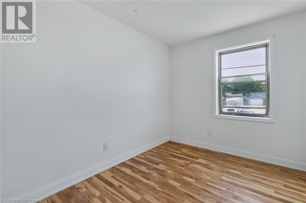 Spare room featuring light wood finished floors and baseboards - 897 Barton Street E, Hamilton, ON - Indoor Photo Showing Other Room