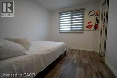 Bedroom with dark wood-style flooring and baseboards - 147 Muriel Crescent, London, ON - Indoor Photo Showing Bedroom