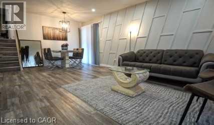 Living area featuring stairway, dark wood-type flooring, and a decorative wall - 147 Muriel Crescent, London, ON - Indoor Photo Showing Living Room