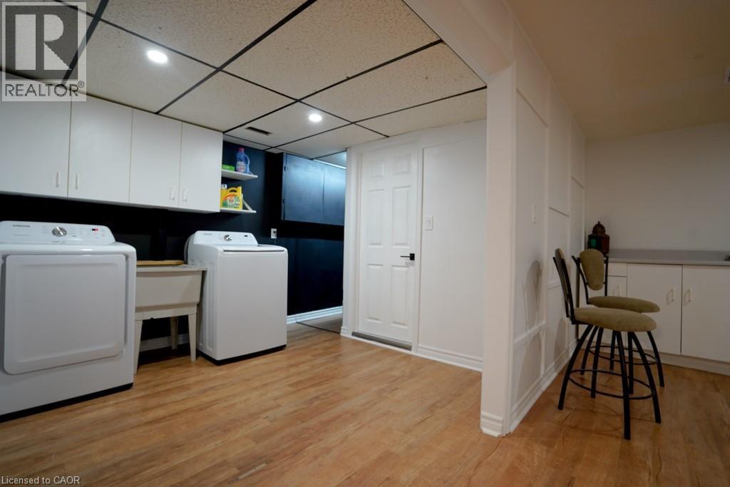 Laundry room featuring a paneled ceiling, light wood finished floors, washing machine and clothes dryer, recessed lighting, and cabinet space - 147 Muriel Crescent, London, ON - Indoor Photo Showing Laundry Room