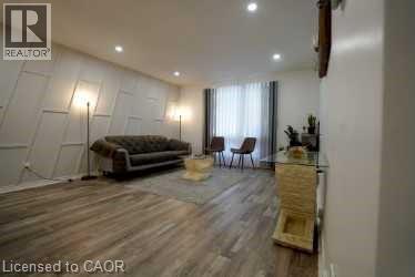 Living area with a decorative wall, recessed lighting, and wood finished floors - 147 Muriel Crescent, London, ON - Indoor