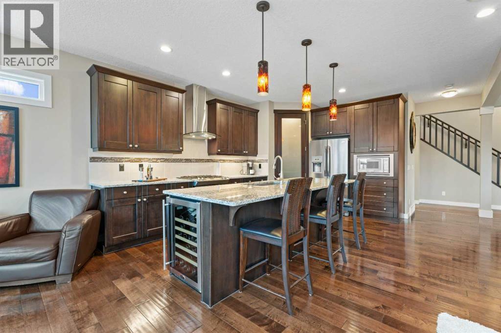Modern kitchen with sleek finishes, ample storage, and a large island, perfect for cooking, entertaining, or gathering with family - 199 Cranarch Landing Se, Calgary, AB - Indoor Photo Showing Kitchen With Upgraded Kitchen