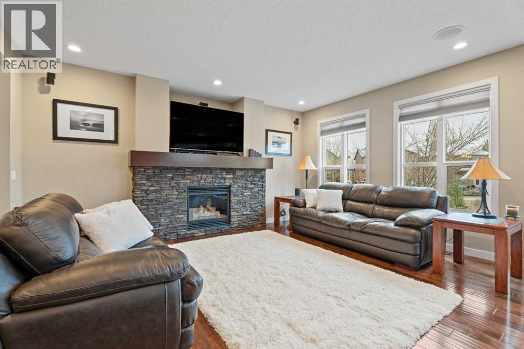Enjoy a warm fireplace and serene backyard views right from your main living area - 199 Cranarch Landing Se, Calgary, AB - Indoor Photo Showing Living Room With Fireplace