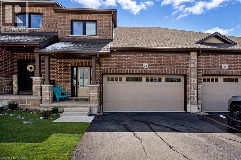 View of front of property with brick siding, a porch, a front yard, asphalt driveway, and a shingled roof - 24 Tamarack Way, Simcoe, ON - Outdoor