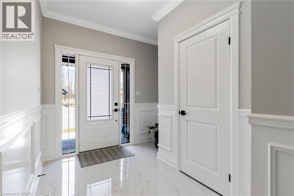 Foyer with crown molding, light marble finish flooring, a wainscoted wall, and a decorative wall - 24 Tamarack Way, Simcoe, ON - Indoor Photo Showing Other Room