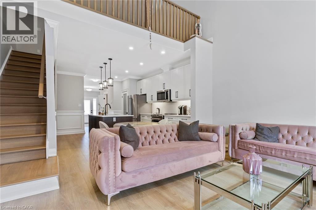Living room with light wood-style flooring, recessed lighting, a decorative wall, ornamental molding, and wainscoting - 24 Tamarack Way, Simcoe, ON - Indoor Photo Showing Living Room